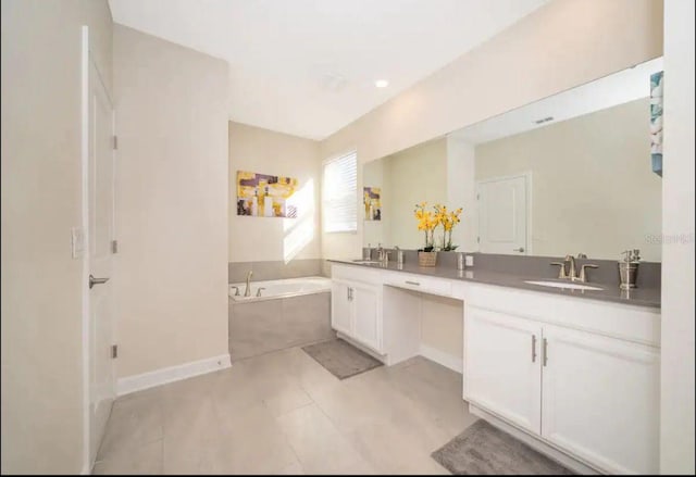 bathroom with tile patterned floors, tiled bath, and vanity