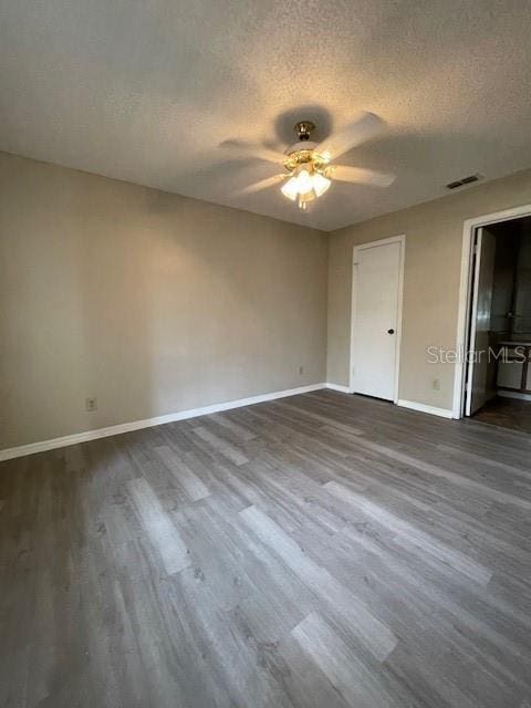 unfurnished bedroom featuring ceiling fan, hardwood / wood-style floors, and a textured ceiling