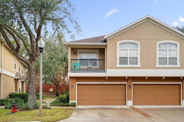 multi unit property featuring an attached garage, concrete driveway, and stucco siding