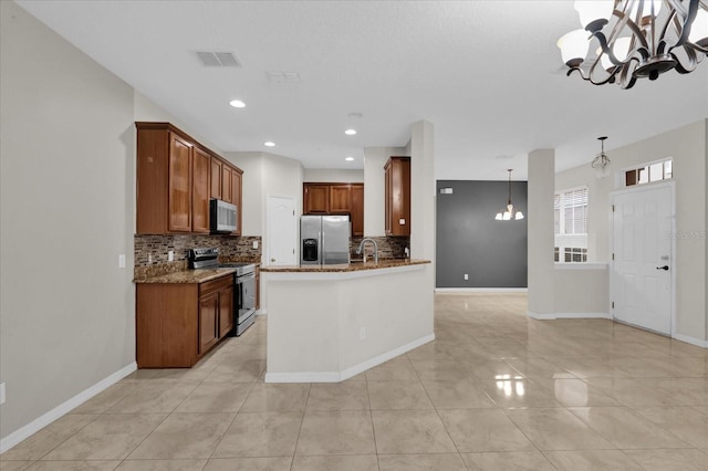 kitchen featuring stone countertops, visible vents, stainless steel appliances, and a notable chandelier