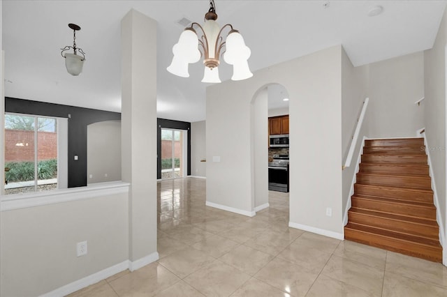 interior space with arched walkways, a notable chandelier, visible vents, baseboards, and stairway