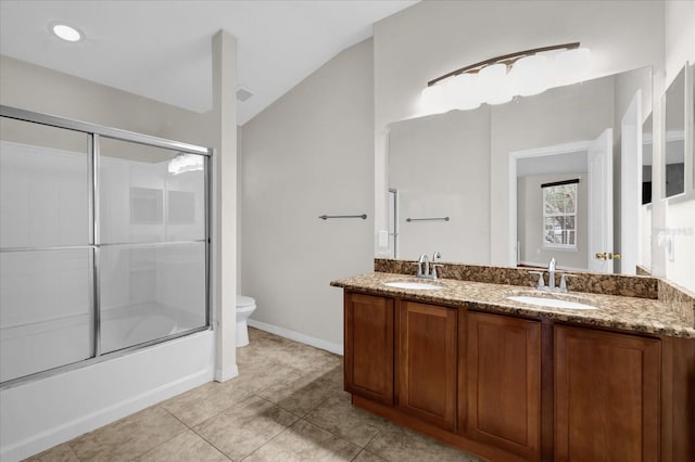 bathroom with lofted ceiling, double vanity, a sink, and toilet