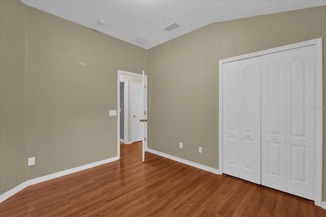 unfurnished bedroom featuring a closet, baseboards, and wood finished floors