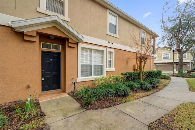 view of exterior entry featuring stucco siding