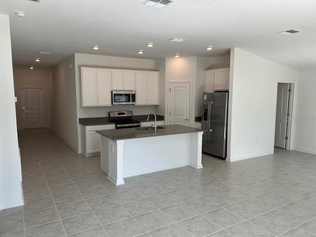 kitchen featuring appliances with stainless steel finishes, white cabinetry, sink, and a center island with sink