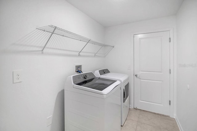 clothes washing area featuring light tile patterned flooring and independent washer and dryer