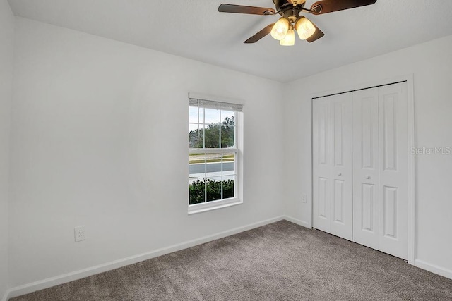 unfurnished bedroom with ceiling fan, a closet, and carpet