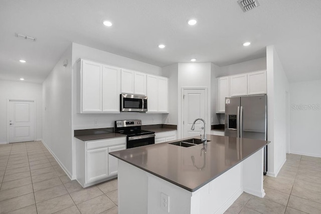 kitchen with white cabinets, a kitchen island with sink, sink, and stainless steel appliances