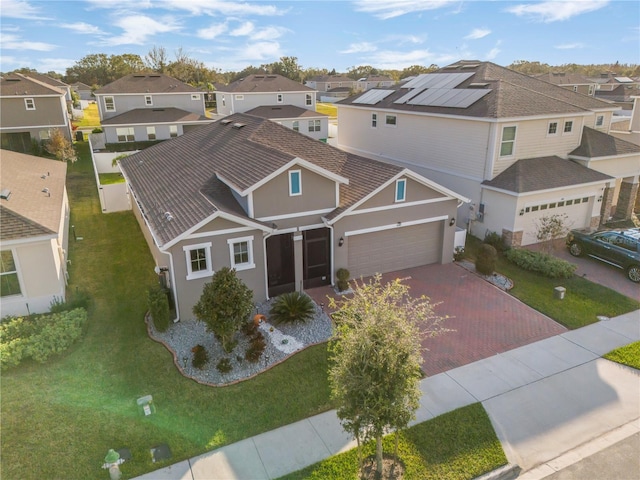 exterior space with solar panels, a front yard, and a garage