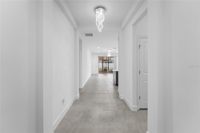 hallway with an inviting chandelier