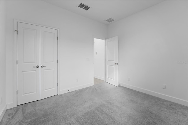 unfurnished bedroom with a closet and light carpet