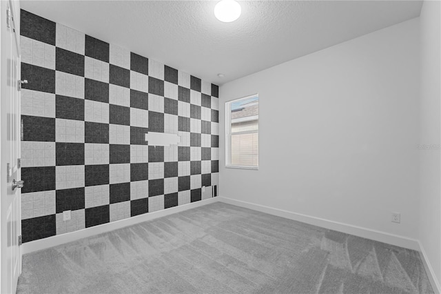 spare room with a textured ceiling and carpet