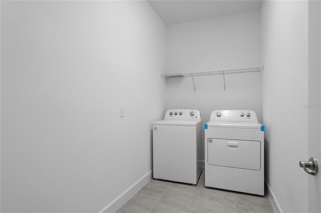 clothes washing area featuring washer and dryer and light tile patterned flooring