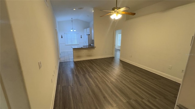 unfurnished living room featuring dark wood-style floors, lofted ceiling, ceiling fan, and baseboards