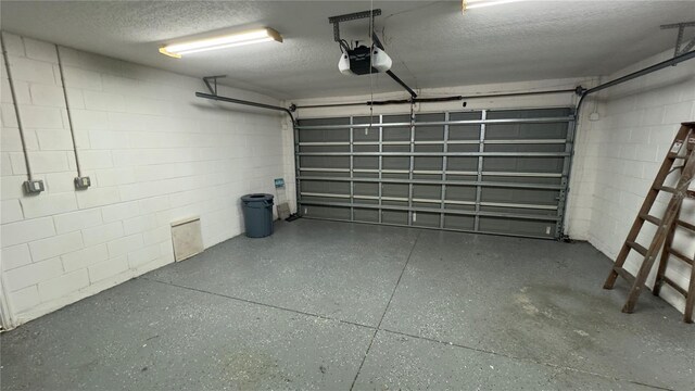 garage with concrete block wall and a garage door opener