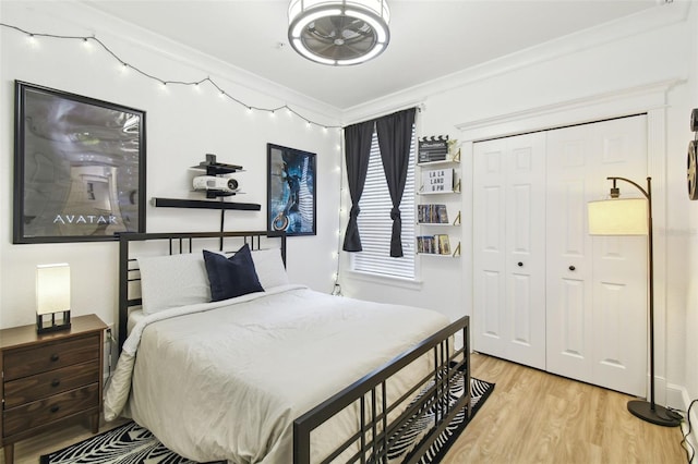 bedroom featuring a closet, ornamental molding, and light hardwood / wood-style floors