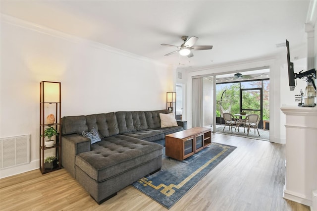 living room featuring light wood-type flooring, ceiling fan, and crown molding