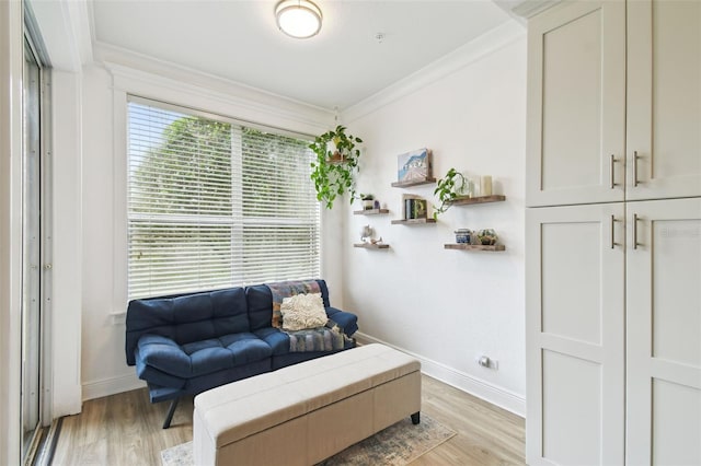 sitting room with crown molding and light wood-type flooring