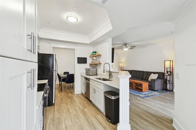 kitchen featuring appliances with stainless steel finishes, light wood-type flooring, ornamental molding, white cabinets, and sink