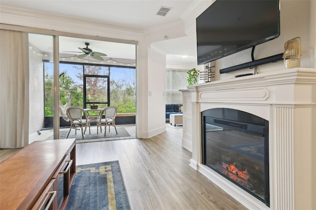 unfurnished living room featuring ceiling fan, crown molding, and hardwood / wood-style flooring