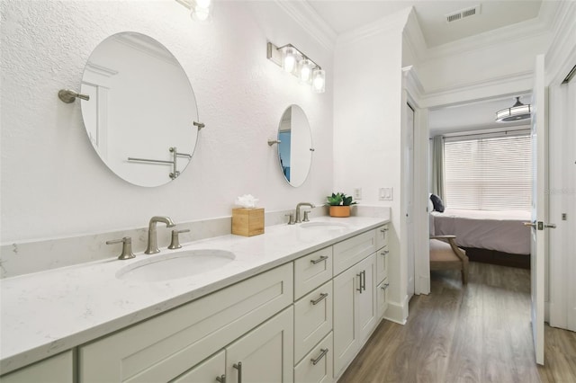 bathroom with hardwood / wood-style flooring, vanity, and ornamental molding