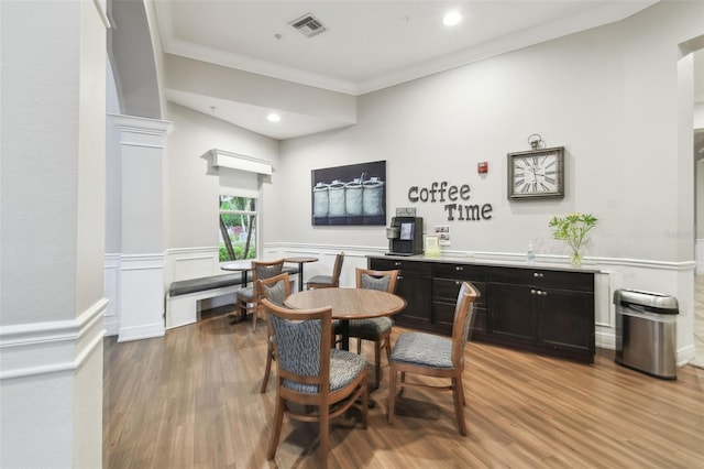 dining space featuring wood-type flooring and ornamental molding