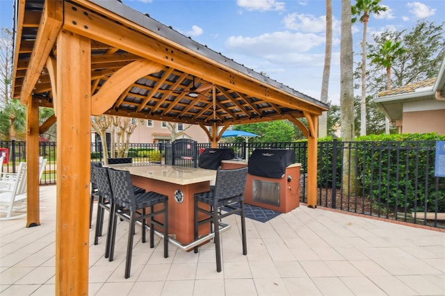 view of patio featuring an outdoor bar, a gazebo, and area for grilling