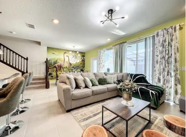 tiled living room with an inviting chandelier and a textured ceiling