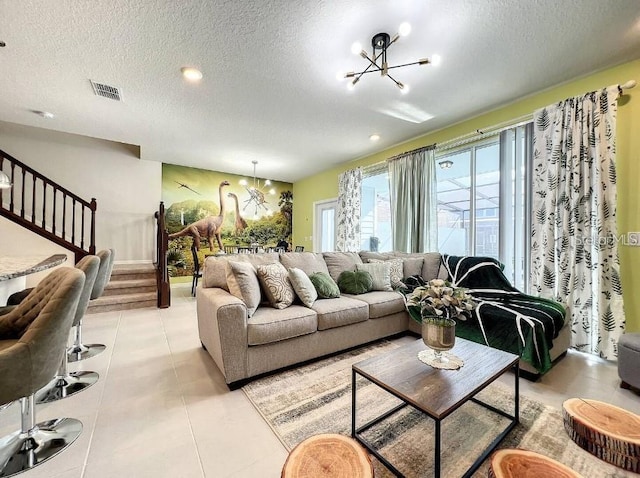 living room featuring a textured ceiling, light tile patterned floors, and a notable chandelier