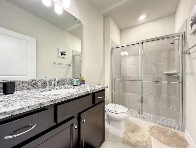 bathroom featuring tile patterned flooring, a shower with shower door, vanity, and toilet