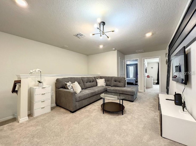 living room featuring a textured ceiling, a notable chandelier, and light colored carpet