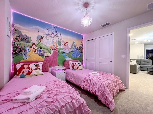 carpeted bedroom featuring a closet and a chandelier