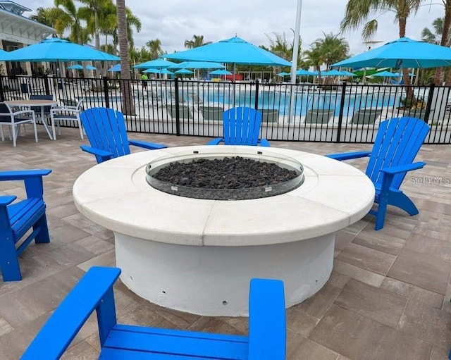 view of patio / terrace with a swimming pool and a fire pit