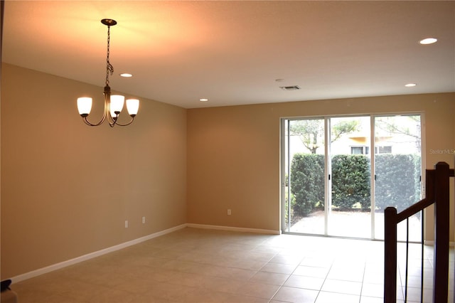 tiled spare room featuring a notable chandelier