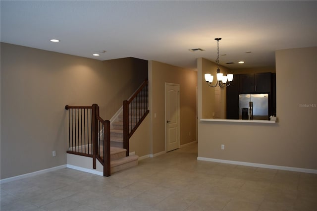 spare room featuring a notable chandelier