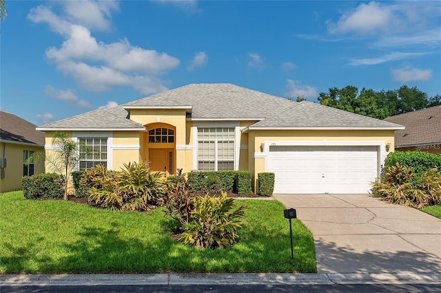 view of front of property with a front yard and a garage