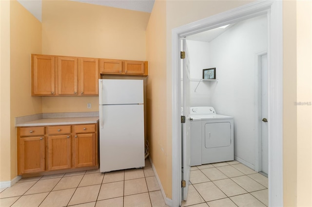 laundry area featuring washer and clothes dryer and light tile patterned floors