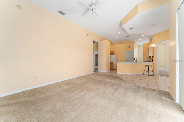 unfurnished living room with ceiling fan and light colored carpet