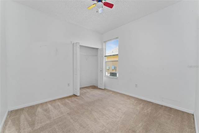 carpeted spare room with a textured ceiling and ceiling fan