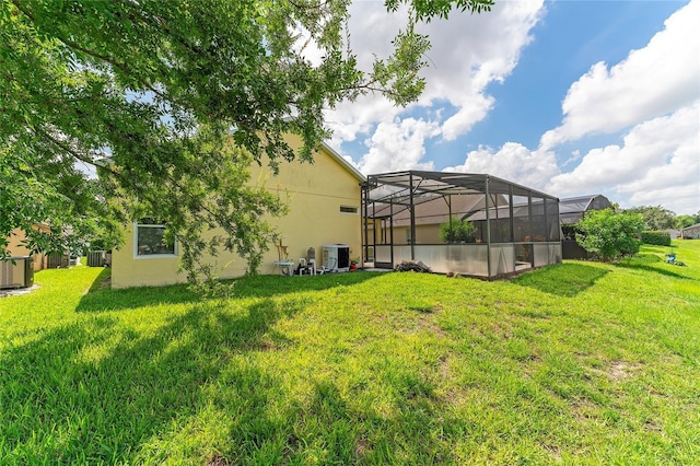 view of yard with central AC and a lanai