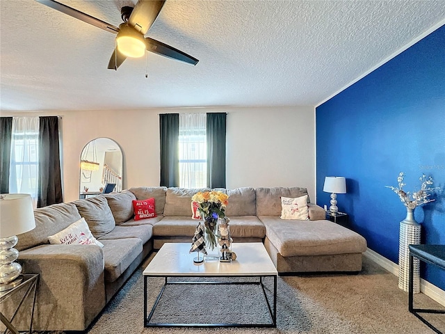 living room with ceiling fan, carpet, and a textured ceiling