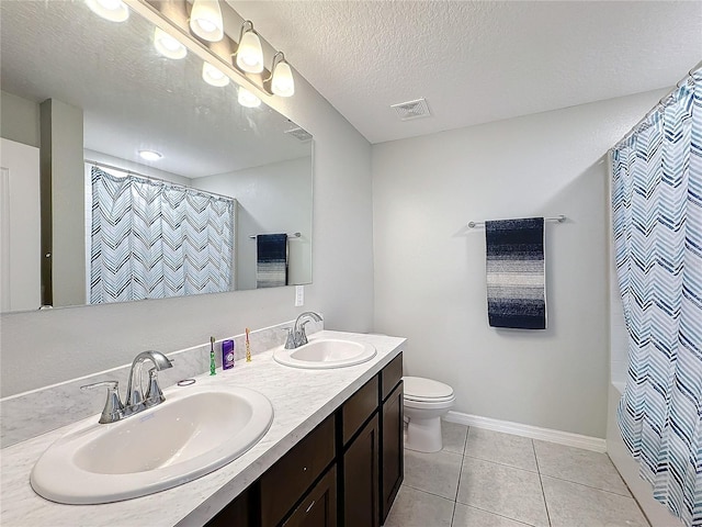 full bathroom featuring vanity, a textured ceiling, tile patterned floors, toilet, and shower / bath combo with shower curtain