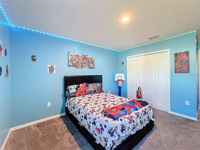 carpeted bedroom with a closet and a textured ceiling