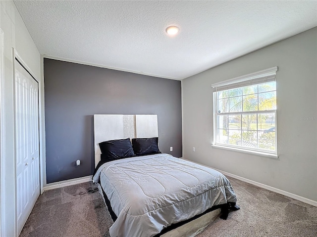 bedroom with carpet floors, a closet, and a textured ceiling