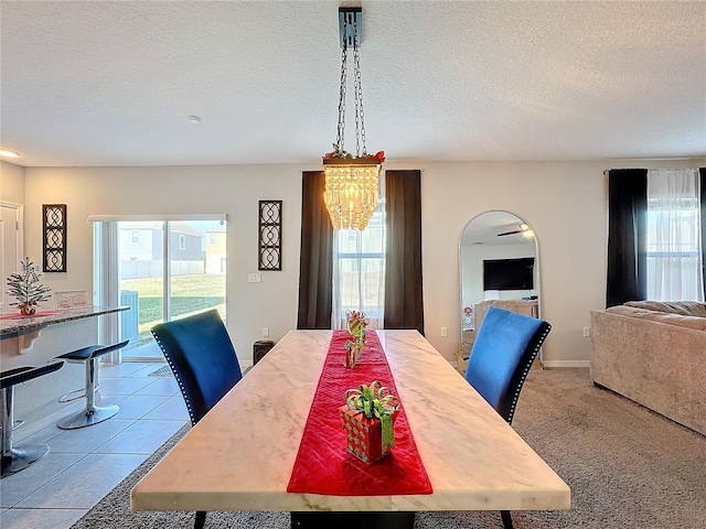 dining room with a notable chandelier, plenty of natural light, and a textured ceiling