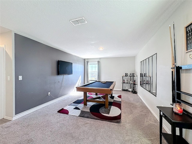 rec room with pool table, light colored carpet, and a textured ceiling