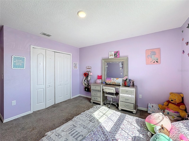 carpeted bedroom with a textured ceiling and a closet