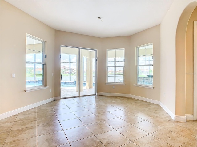 doorway with light tile patterned floors and plenty of natural light