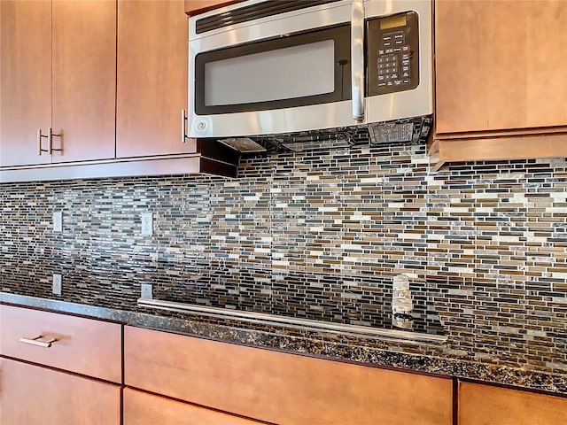 room details with backsplash and dark stone counters