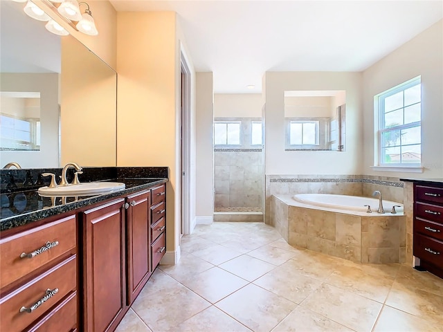 bathroom with vanity, tile patterned flooring, plenty of natural light, and plus walk in shower